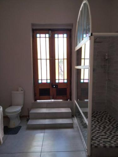 a bathroom with a toilet and a glass door at Via the Grapevine 3 bedroom house private parking in Colesberg