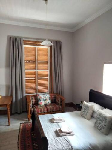 a living room with a bed and a couch at Via the Grapevine 3 bedroom house private parking in Colesberg