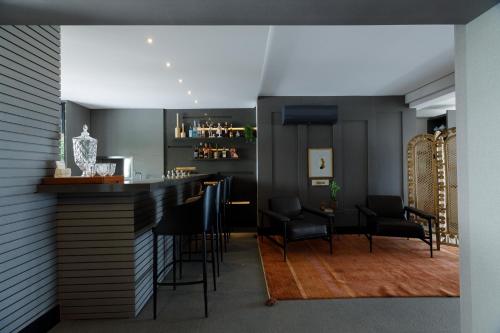 a bar with black chairs and a table in a room at Villa d'Ozio Hotel e Cucina in Itajaí