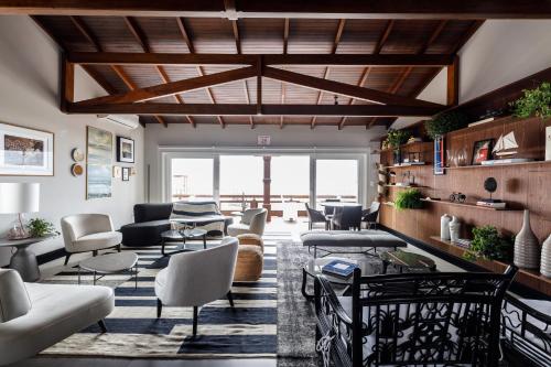 a living room with a lot of chairs and tables at Villa d'Ozio Hotel e Cucina in Itajaí