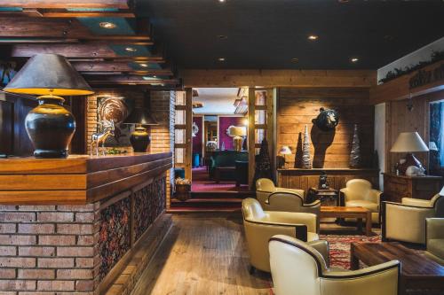 a lobby of a restaurant with chairs and tables at Hotel Les Mélèzes in Les Deux Alpes