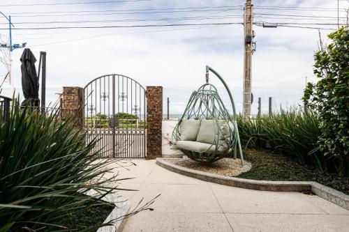 a swing in a garden next to a gate at Villa d'Ozio Hotel e Cucina in Itajaí