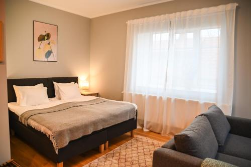 a bedroom with a bed and a couch and a window at Tohi Distillery apartments in Kohila
