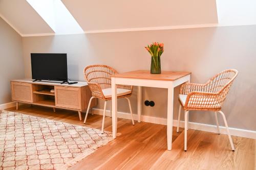 a room with a table and two chairs and a television at Tohi Distillery apartments in Kohila