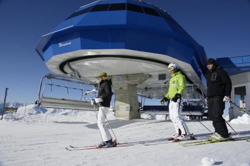 three people on skis in front of a building at Pension Tirol in Nauders