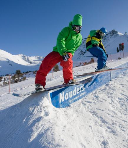 two people on skis on a rail in the snow at Pension Tirol in Nauders