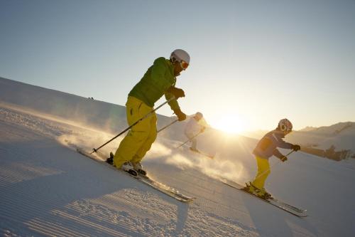 a group of people skiing down a snow covered slope at Pension Tirol in Nauders