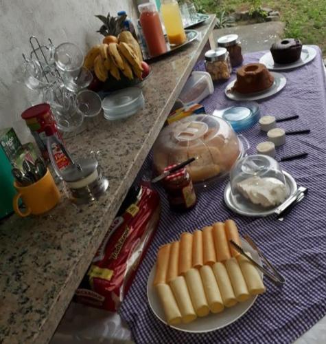 a table with plates of food on a table at Pousada Recanto das Oliveiras-Búzios in Búzios