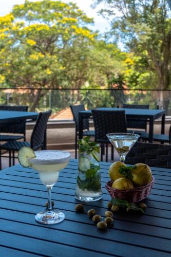 a blue table with two glasses and a bowl of fruit at Complexo Eco Cataratas Resort by SJ in Foz do Iguaçu