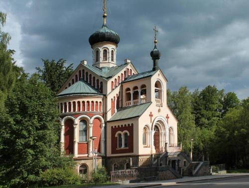 a large building with a tower on top of it at Villa Patriot Boutique Hotel in Mariánské Lázně