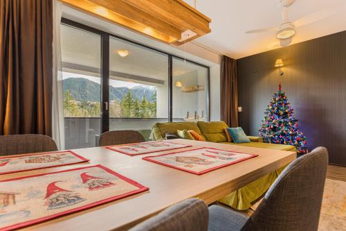 a living room with a christmas tree and a table at MAIO Studio Silver Mountain Poiana Brasov in Poiana Brasov
