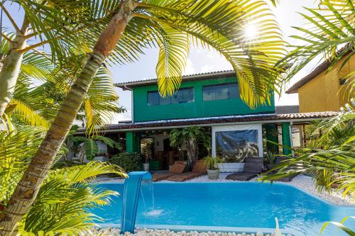 a house with a swimming pool and palm trees at Taverna do Paraiso in Janga