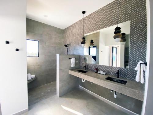 La salle de bains est pourvue d'un lavabo et d'un miroir. dans l'établissement Hotel Todo Bien, à La Ventana