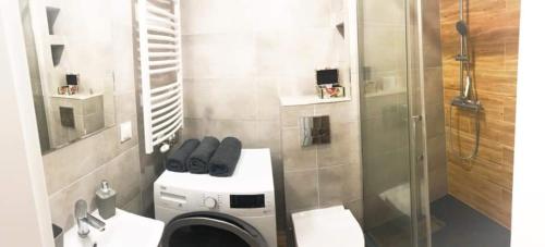 uma casa de banho com uma máquina de lavar roupa e um chuveiro em Apartament Konin Prestige em Konin