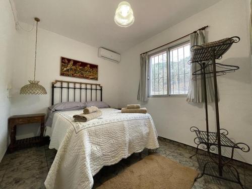 1 dormitorio con 1 cama con 2 toallas en Casa Rural Los Caleros, en Fondón