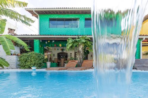 a pool with a water fountain in front of a house at Taverna do Paraiso in Janga