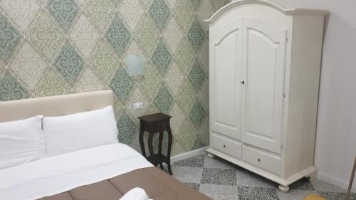 a bedroom with a bed and a cabinet in it at B&B By the Station in Battipaglia
