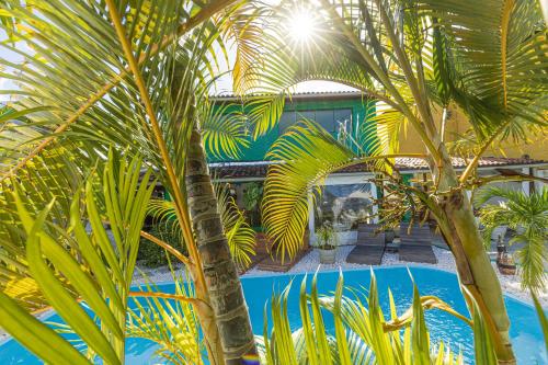 a palm tree in front of a swimming pool at Taverna do Paraiso in Janga