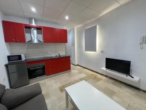 a living room with red cabinets and a kitchen at Apartamento en Olula del Río in Olula del Río