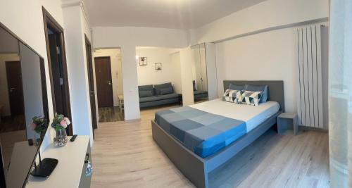 um quarto com uma cama e uma sala de estar em New Studio em Piteşti