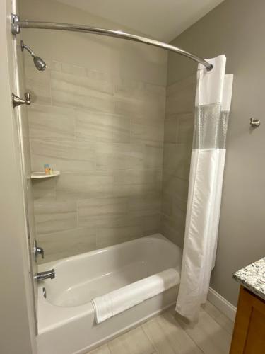 紹斯波特的住宿－River Hotel of Southport，带淋浴的浴室配有白色浴缸。
