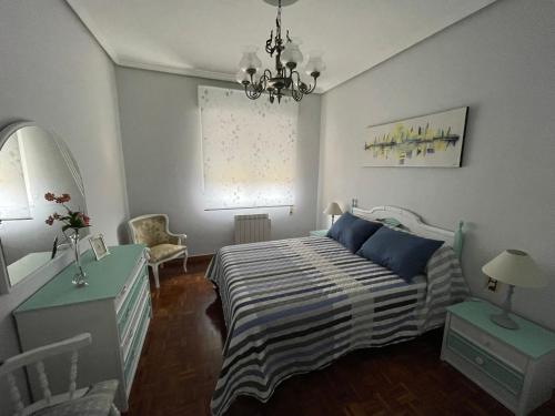 - une chambre avec un lit et un lustre dans l'établissement Apartamento en entorno natural, La biblioteca, à Figaredo