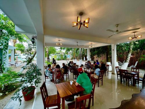 a group of people sitting at tables in a restaurant at Hotel Casa Lima Bacalar in Bacalar
