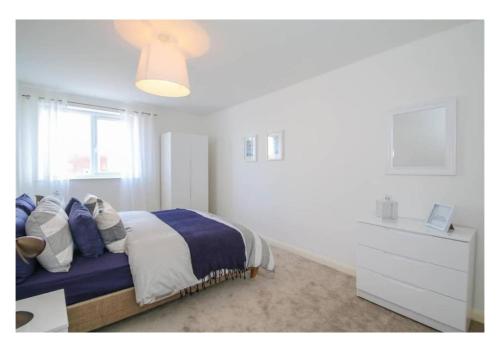 een slaapkamer met een bed, een dressoir en een raam bij 3 Bedroom Beautiful Apartment in Manchester