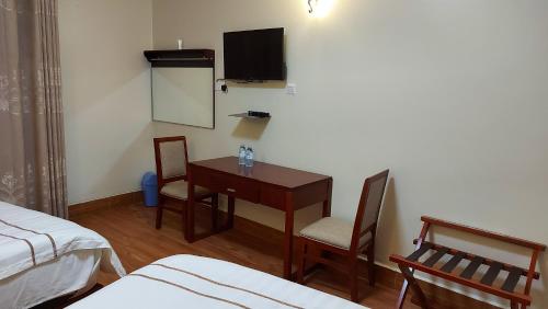 a room with a desk and a table and chairs at Asamar Country Resort in Mbarara