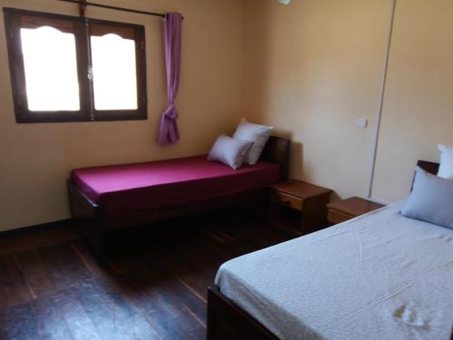 a small room with two beds and a window at Villa Nature in Toliara