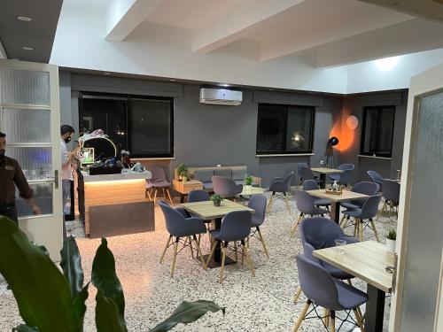 a restaurant with tables and chairs in a room at The Y Hotel in Amman