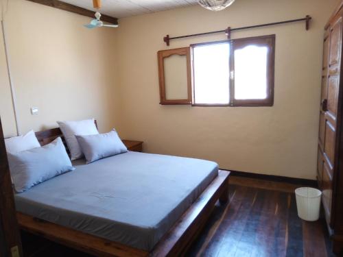 a bedroom with a large bed with a window at Villa Nature in Toliara