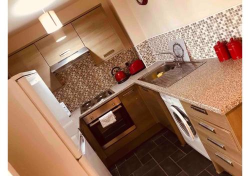 a small kitchen with a stove and a sink at 3 Bedroom Beautiful Apartment in Manchester
