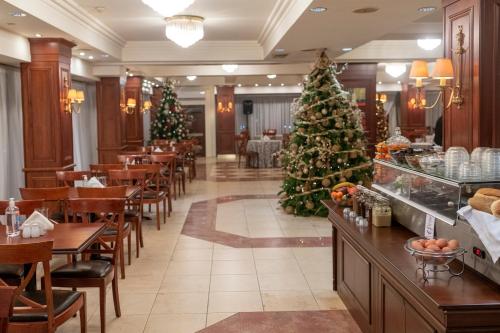 a christmas tree in a restaurant with christmas decorations at Lingos Hotel in Florina