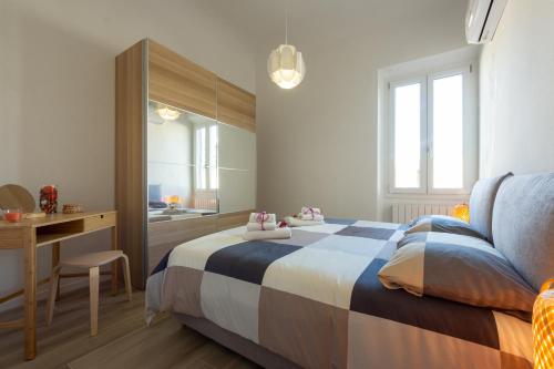 a bedroom with a bed and a desk and a mirror at Mosse Leopolda Apartment by Mamo Florence in Florence