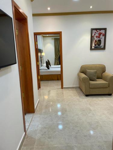 a living room with a couch and a flat screen tv at روح الأصيلة للشقق المخدومة Roh Alaseilah Serviced Apartments in Taif