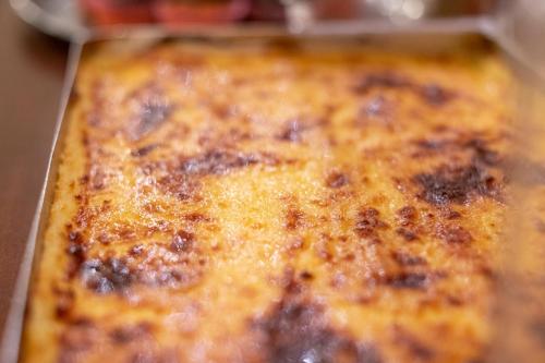 a close up of a cheese pizza in a pan at Lingos Hotel in Florina
