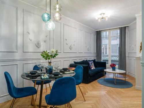 een woonkamer met een tafel en blauwe stoelen bij The Blue Pearl in Parijs