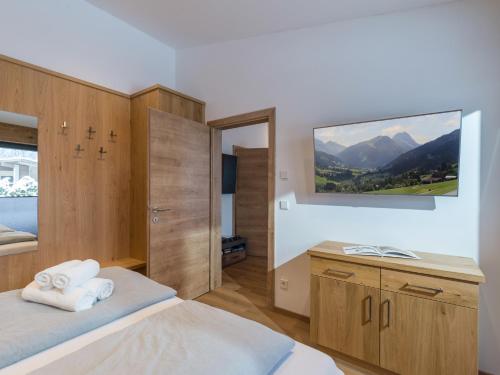 um quarto com uma cama, uma secretária e uma televisão em Appartement Gaisbergblick em Kirchberg in Tirol