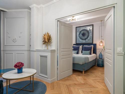 een slaapkamer met een bed en een tafel in een kamer bij The Blue Pearl in Parijs