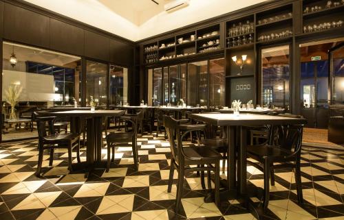 a restaurant with tables and chairs on a checkered floor at LAS LIEBRES RESTAURANT & HOTEL in Colonia del Sacramento