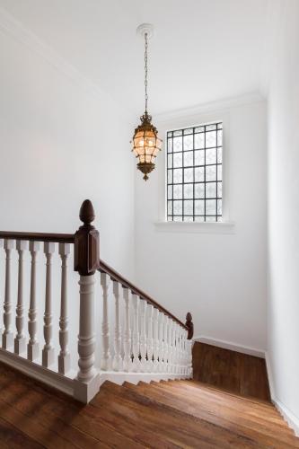 a staircase with a chandelier and a window at LAS LIEBRES RESTAURANT & HOTEL in Colonia del Sacramento