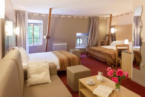 une chambre d'hôtel avec deux lits et un canapé dans l'établissement BRIT HOTEL Le Lion d'Or CHINON, à Chinon