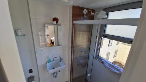 ein kleines Bad mit einem Waschbecken und einem Fenster in der Unterkunft ESTÚDIO 328 DA SERRA/TERESÓPOLIS RJ in Teresópolis