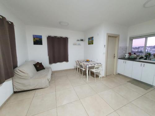 a kitchen and a living room with a table and a couch at קשת לכנרת in Keshet