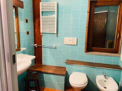 bagno blu con servizi igienici e lavandino di Hotel La Fontaine a Sauze d'Oulx