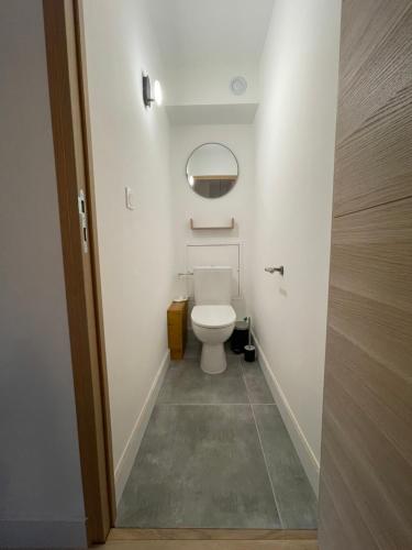 uma casa de banho com um WC branco num quarto em APPARTEMENT STATION LA JOUE DU LOUP PIED DES PISTES em Le Dévoluy