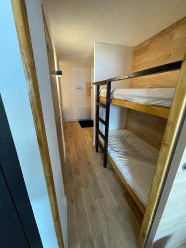 a room with two bunk beds and a hallway at APPARTEMENT STATION LA JOUE DU LOUP PIED DES PISTES in Le Dévoluy