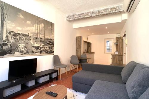 uma sala de estar com um sofá e uma televisão em BNB RENTING Atypical condo in rue Fourmillière em Antibes