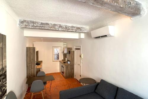 uma sala de estar com um sofá e uma cozinha em BNB RENTING Atypical condo in rue Fourmillière em Antibes
